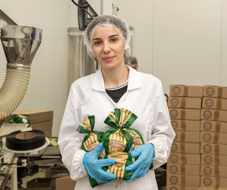 Сотрудница производства с упаковками продукции